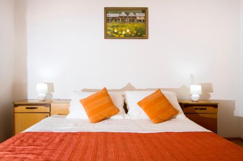 a bedroom with a bed with orange and white pillows at Apartman Karlo in Otočac