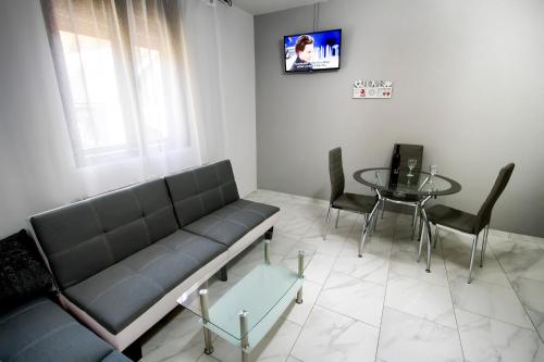 a living room with a couch and a glass table at Apartman Karlo in Otočac