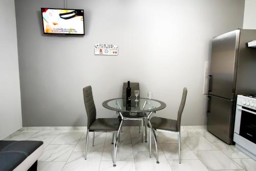 a kitchen with a table and chairs and a refrigerator at Apartman Karlo in Otočac