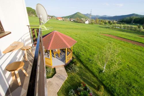 a small gazebo on a balcony with a green field at Apartman Karlo in Otočac