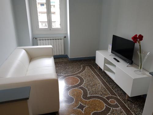 - un salon avec un canapé blanc et une télévision dans l'établissement apartment genova central, à Gênes