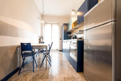 a kitchen with a table and chairs and a refrigerator at Hotel Lis in Asti