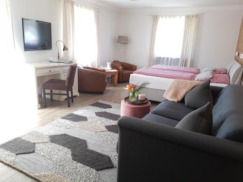 a living room with a couch and a bed at Alpinhotel INzeller in Inzell