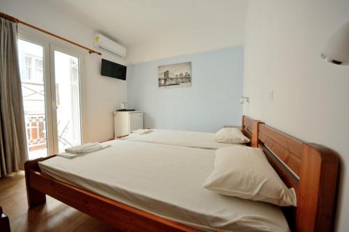 a large bed in a room with a large window at Lampis Studios in Pythagoreio