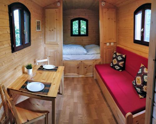 een tiny house met een tafel en een bed bij Roulotte Comtoise à Strasbourg in Straatsburg