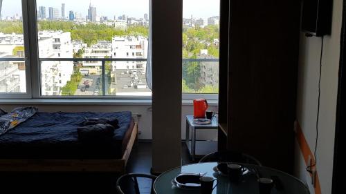 a bedroom with a bed and a large window at Walk distance to mokotow business park in Warsaw