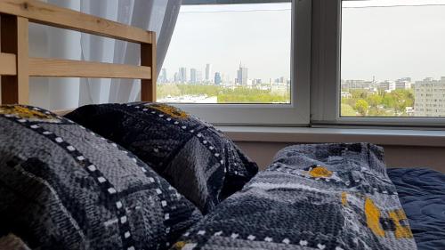 a couch with pillows in front of a window at Walk distance to mokotow business park in Warsaw