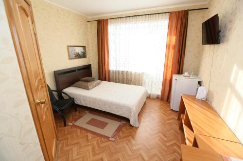 a small bedroom with a bed and a window at Venecia in Usinsk