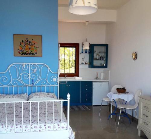 una camera da letto con pareti blu, un letto e un tavolo di Marvelous Sea View Eco Studio ad Ammouliani