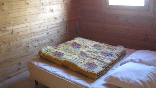 Habitación con 2 camas en una pared de madera. en Chalet des Grands Prés en Gercourt-et-Drillancourt