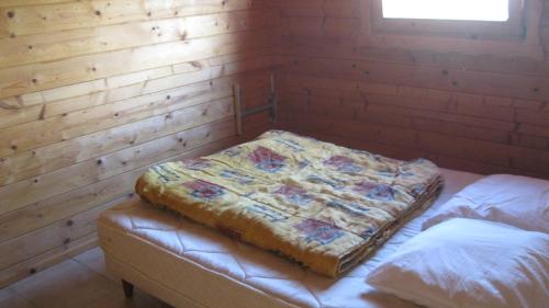 Cette chambre est dotée de 2 lits dans un mur en bois. dans l'établissement Chalet des Grands Prés, à Gercourt-et-Drillancourt