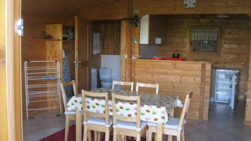 a dining room with a table and chairs and a kitchen at Chalet des Grands Prés in Gercourt-et-Drillancourt