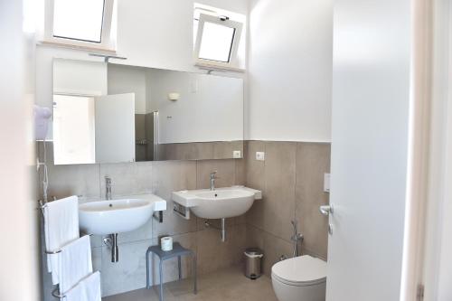 a bathroom with two sinks and a toilet at Agriturismo Giorgio in Mattinata