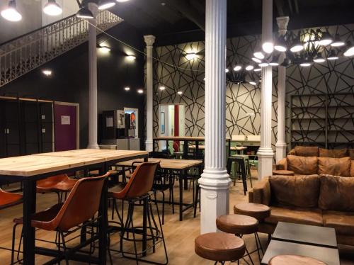 a restaurant with tables and chairs and a couch at Safestay Barcelona Gothic in Barcelona