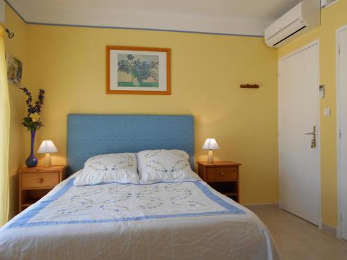 łóżko z niebieskim zagłówkiem w sypialni w obiekcie Les Tilleuls B&B w Orange
