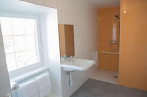 a bathroom with a sink and a window and a tub at Le Soleil d'Or in Metzeral