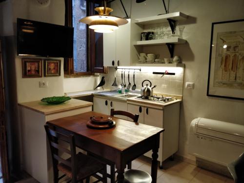 a small kitchen with a table and a sink at Casa Messi in Pitigliano