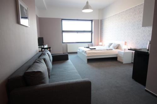 a living room with a couch and a bed at Downtown Apartments in Plzeň