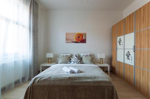 プラハにあるKubelikova APARTMEETのベッドルーム1室(大型ベッド1台、テーブル2台付)