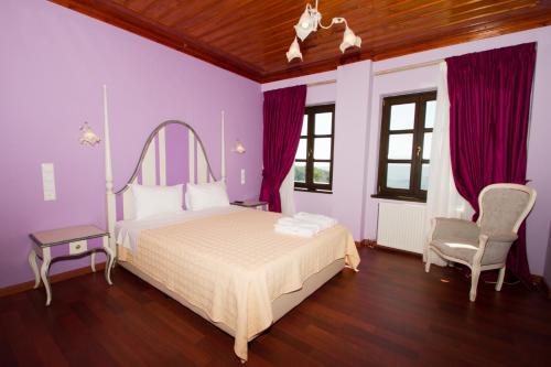 a bedroom with a white bed and purple walls at Hotel Monodendri in Monodendri