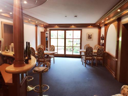 a dining room with a table and chairs and a window at Hotel am Wiesenhang - Garni in Bad Kohlgrub