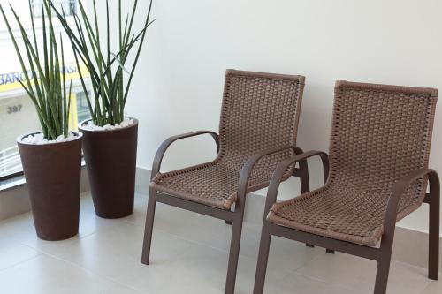 two chairs and two potted plants in a room at Jabó Inn Hotel in Jaboticatubas