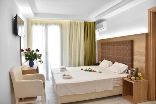 a hotel room with a bed and a chair at Artemis Hotel Apartments in Hersonissos