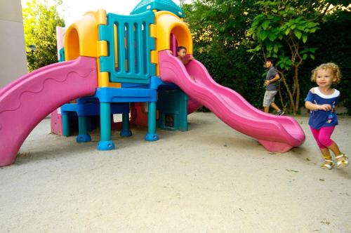two children playing on a slide at a playground at Aparthotel Cye Holiday Centre in Salou
