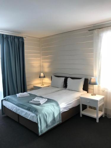 a bedroom with a large bed with two tables and two lamps at Blyzhche Neba in Yablunytsya