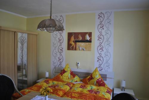 a bedroom with a bed with colorful pillows at Guest house Mückenheim in Benneckenstein