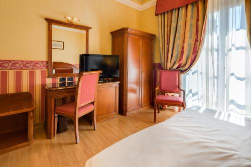 a hotel room with a bed and a desk and a television at Hotel San Donato - Bologna centro in Bologna