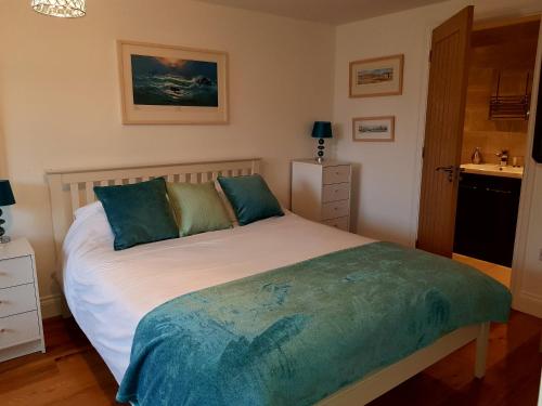 a bedroom with a large white bed with blue pillows at Primrose House in St Ives
