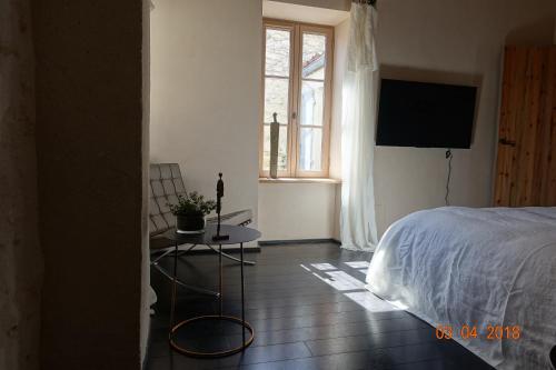 a bedroom with a bed and a table and a window at Les Clés d'Ars in Ars-en-Ré