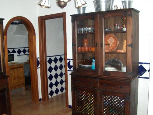 a kitchen with a wooden cabinet and a mirror at A casa da Maria in Luz de Tavira