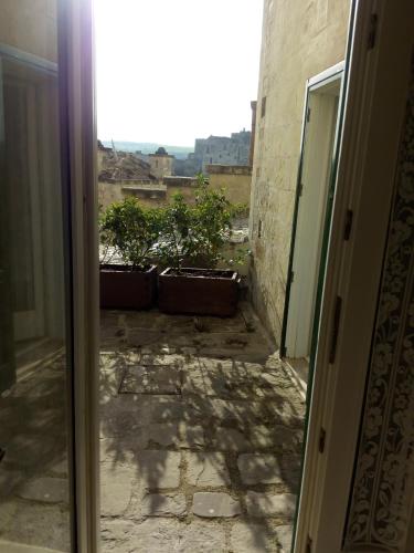 an open door with potted plants on a balcony at San Biagio Materapartment in Matera