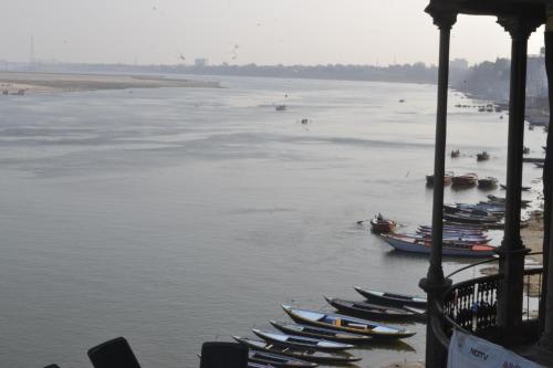 a group of boats are lined up in the water at Hotel Sita Place On Heritage Ghats Of Benaras in Varanasi
