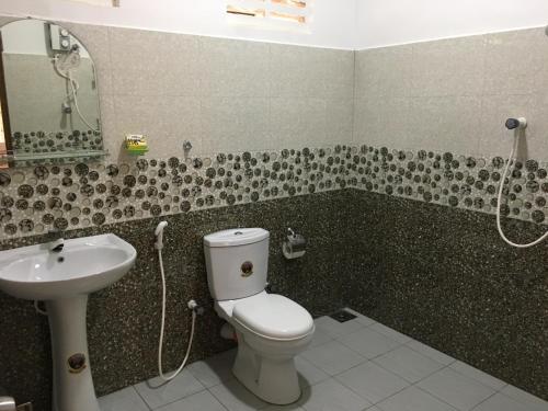a bathroom with a toilet and a sink at Sigiri Rangana Guesthouse in Sigiriya