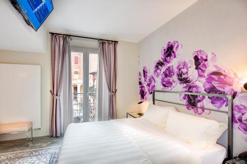 a bedroom with a bed with purple flowers on the wall at Il Convento Dei Fiori Di Seta in Bologna