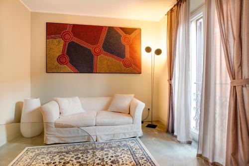 a living room with a white couch and a rug at Il Convento Dei Fiori Di Seta in Bologna