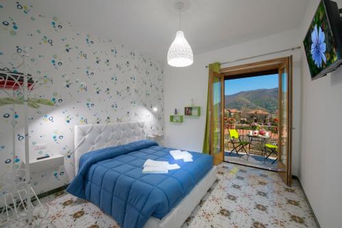 een slaapkamer met een blauw bed en een televisie bij Casa Loreto, Agerola in Agerola