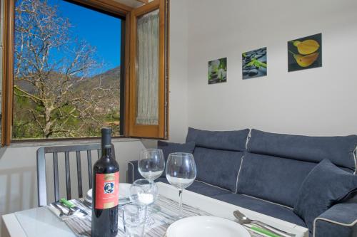 a bottle of wine sitting on a table with two wine glasses at Casa Loreto, Agerola in Agerola