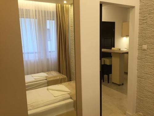 a hotel room with two beds and a mirror at Mosoly Szallashely in Szeged