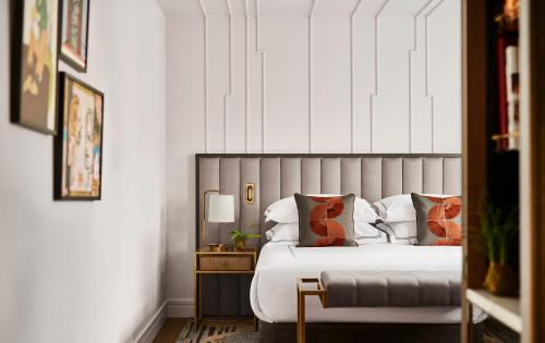 ein Schlafzimmer mit einem Bett und einem Tisch mit einer Lampe in der Unterkunft Gran Hotel Inglés - The Leading Hotels of the World in Madrid