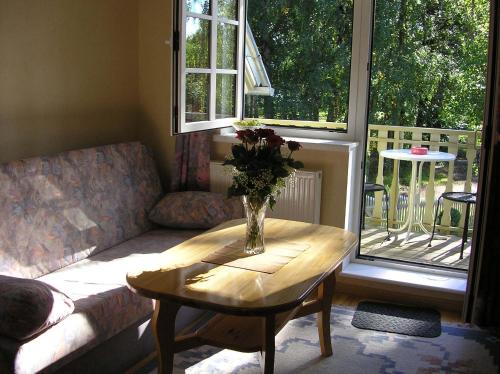 ein Wohnzimmer mit einem Tisch und einer Blumenvase darauf in der Unterkunft Villa Johanna Guesthouse in Pärnu