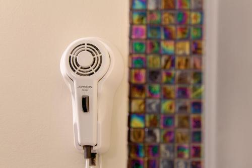 a white hairdryer hanging on a wall next to a wall at Il Convento Dei Fiori Di Seta in Bologna
