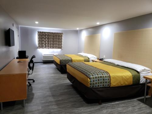 a hotel room with two beds and a desk at Regal Inn in Los Angeles