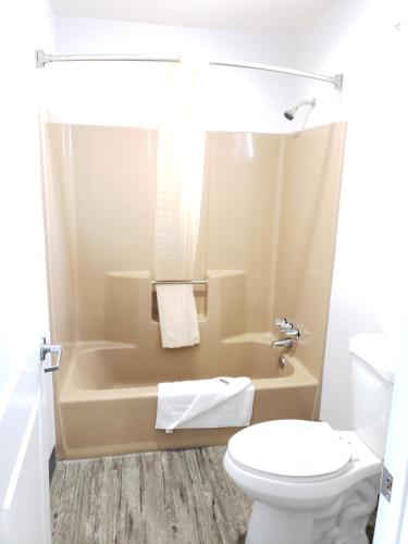 a bathroom with a toilet and a tub and a sink at Regal Inn in Los Angeles
