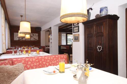 a dining room with two tables with white tablecloths at Pension Garni Gerhard in Oetz