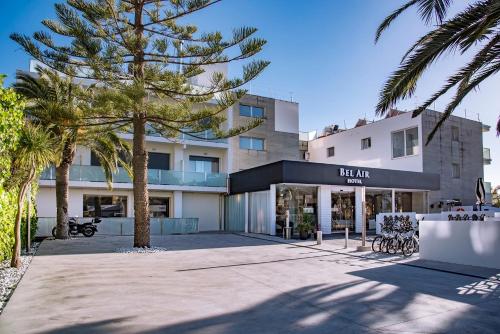 a building with palm trees in front of it at Bel Air in Castelldefels