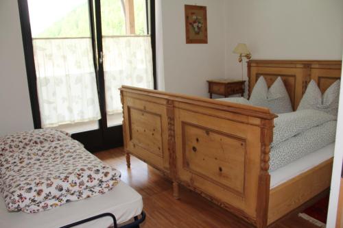 a bedroom with a wooden bed and two windows at Residence Flora in Solda